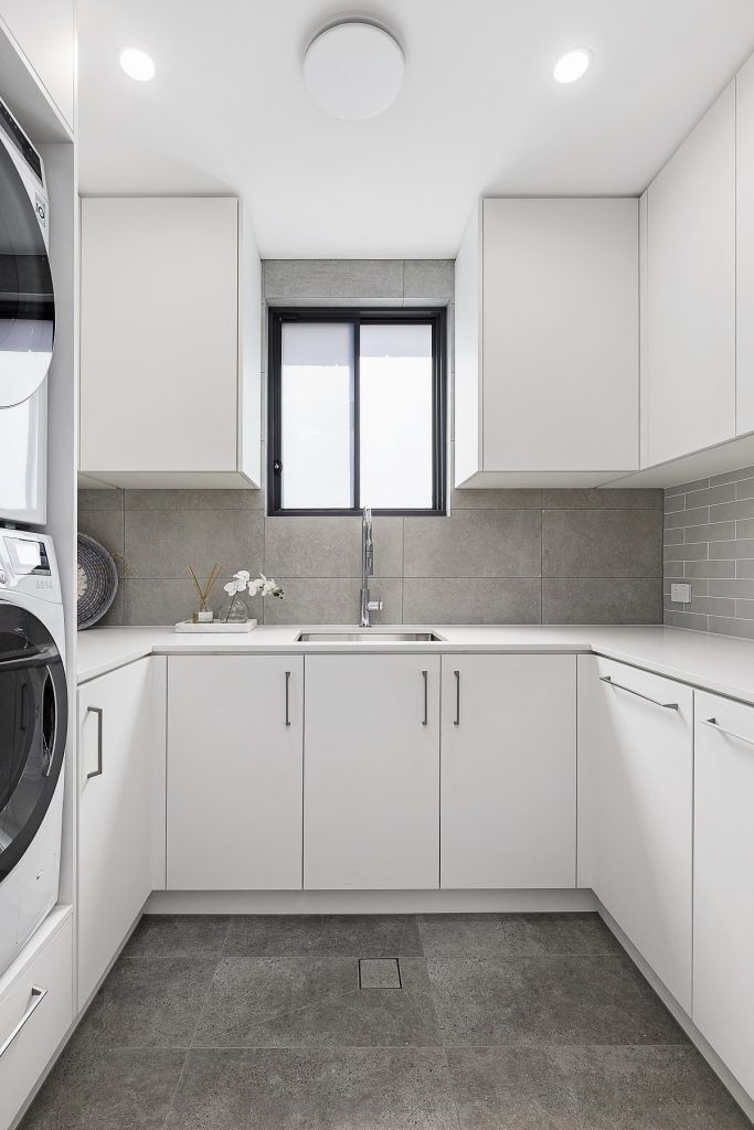 Custom Laundry fitout with stone benchtop, pull out washing baskets and built in laundry chute - Chipping Norton, Sydney