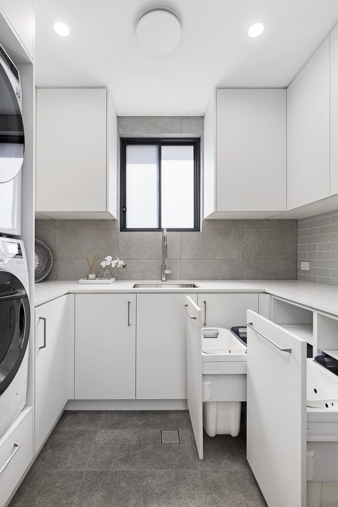 Custom Laundry fitout with stone benchtop, pull out washing baskets and built in laundry chute - Chipping Norton, Sydney
