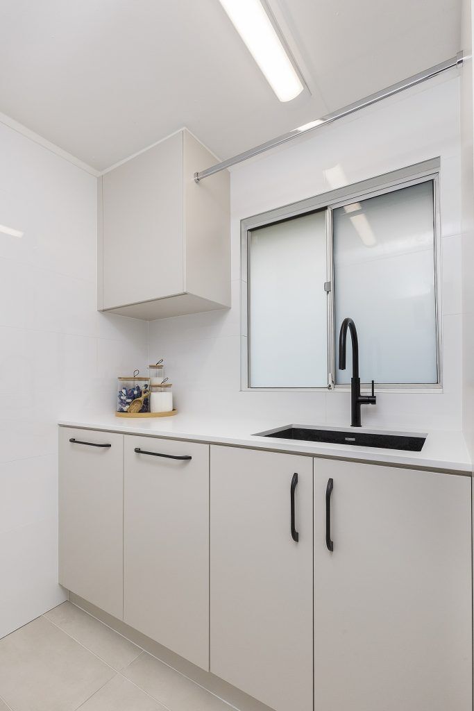 Polyurethane laundry with stone benchtop and hanging rail - Moorebank, Sydney