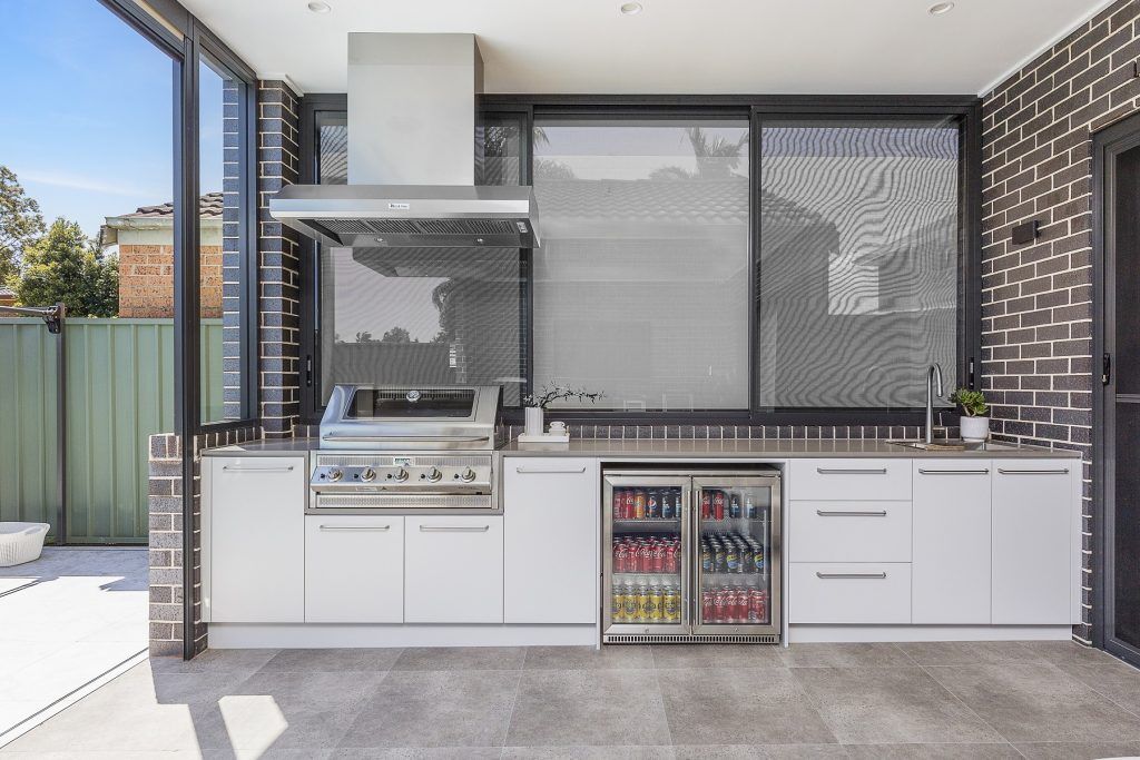 Custom outdoor kitchen with BBQ set up and pull out bins - Chipping Norton