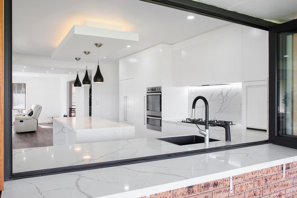 Kenthurst, Vivid White Polyurethane doors with a 40mm Statuario Caesarstone Island bench and Caesarstone splashback