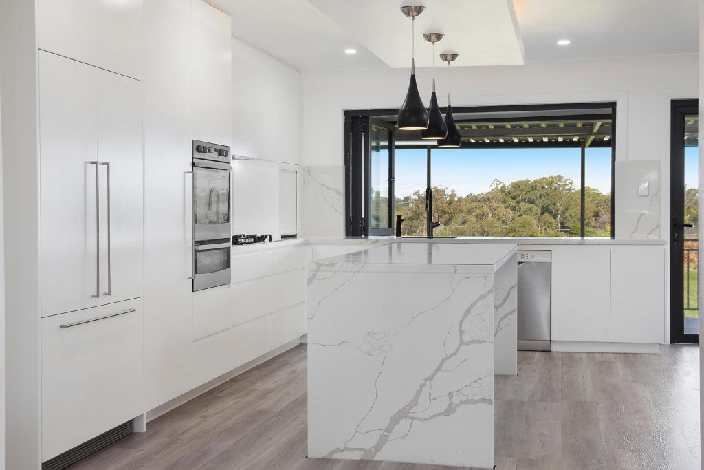 Kenthurst, Vivid White Polyurethane doors with a 40mm Statuario Caesarstone Island bench and Caesarstone splashback