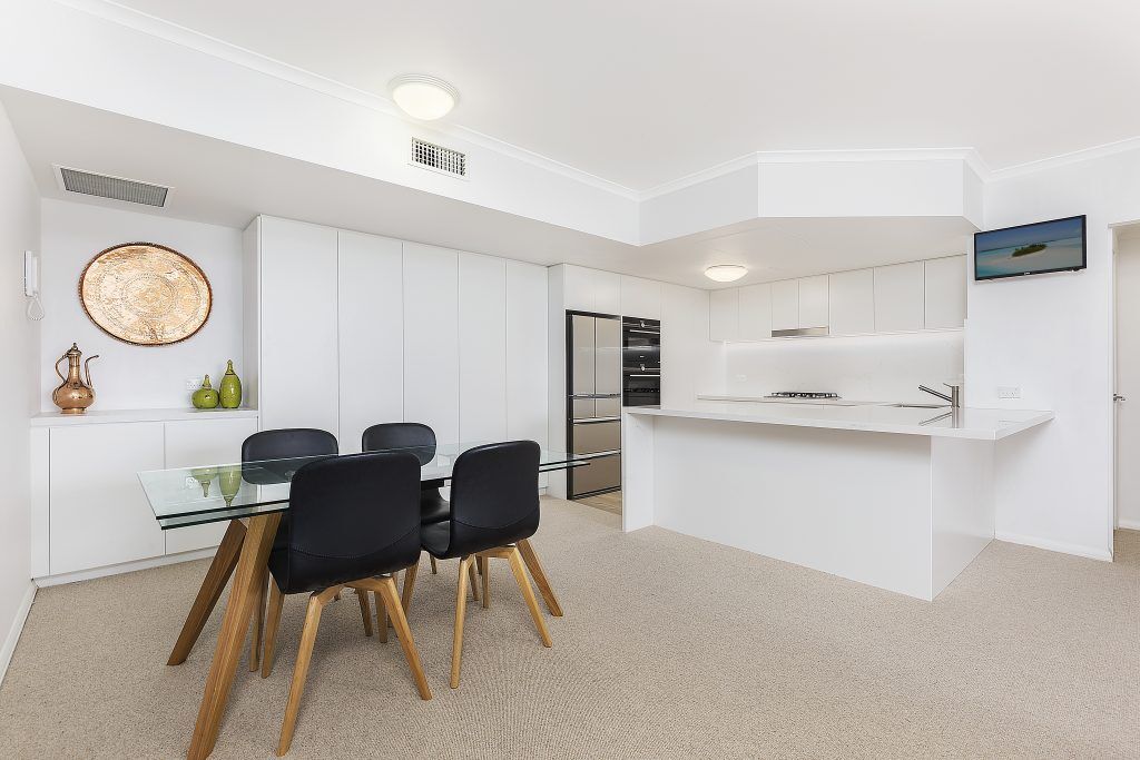 AFTER Manly Renovation - Satin Polyurethane Kitchen with electronic push open drawers and a Quantum Quartz stone benchtop and splashback in Michelangelo