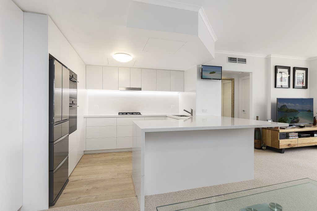 AFTER Manly Renovation - Satin Polyurethane Kitchen with electronic push open drawers and a Quantum Quartz stone benchtop and splashback in Michelangelo