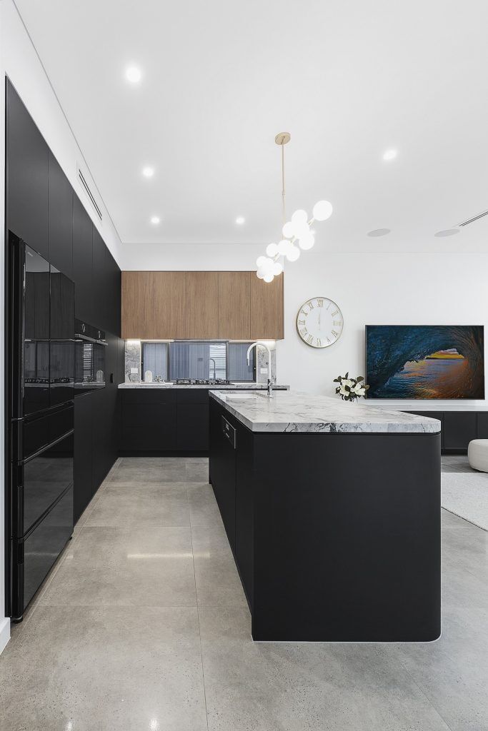 Chipping Norton, Matt black kitchen featuring Super White Stone benches and a curved edge island