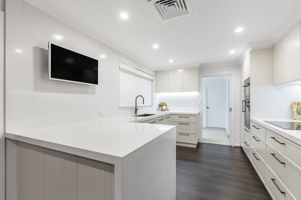 AFTER Moorebank Renovation, Polyurethane Thin Shaker kitchen with a stone benchtop and featuring a fluted paneled breakfast bar