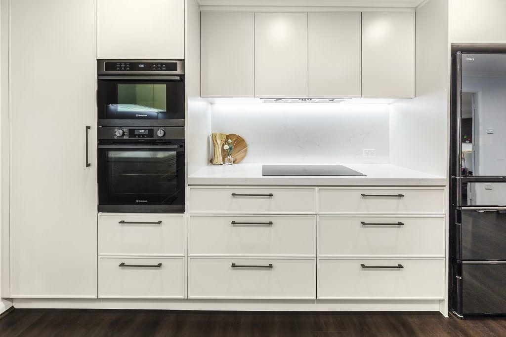 Moorebank, Polyurethane Thin Shaker kitchen with a Quantum Quartz stone benchtop and splashback in Michelangelo and featuring a fluted paneled breakfast bar