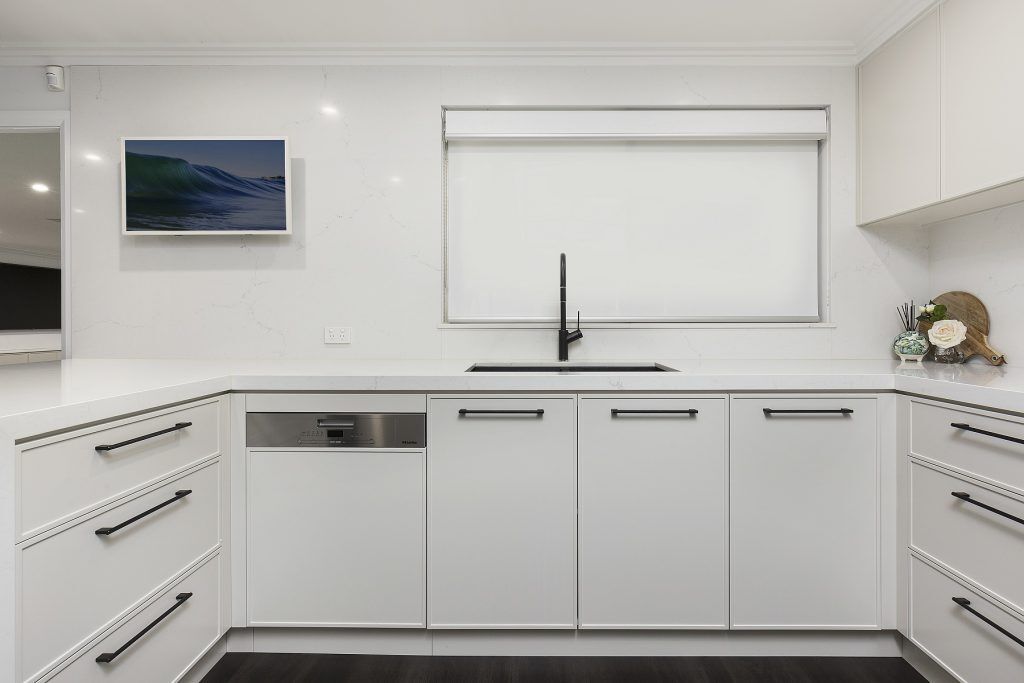 Moorebank, Polyurethane Thin Shaker kitchen with a Quantum Quartz stone benchtop and splashback in Michelangelo and featuring a fluted paneled breakfast bar