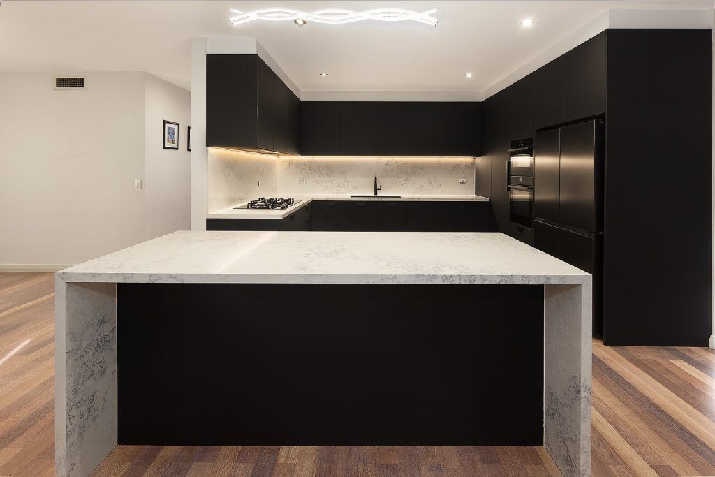 AFTER Casula Renovation, Matt Black cabinets with Quantum Quartz stone island bench, benchtops and splashback in Monte Bianco