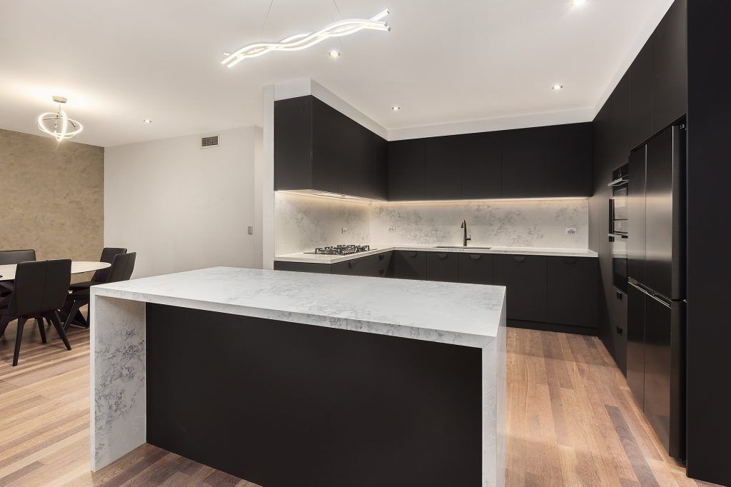 Casula, Matt Black cabinets with Quantum Quartz stone island bench, benchtops and splashback in Monte Bianco